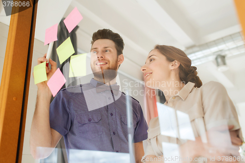 Image of creative team with stickers on glass at office