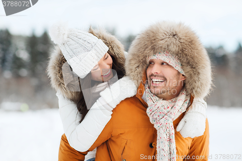 Image of happy couple having fun over winter background