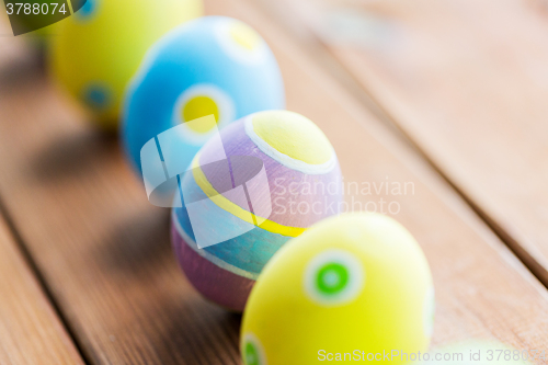 Image of close up of colored easter eggs on wooden surface