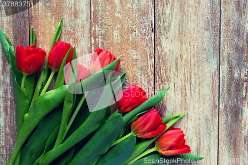 Image of close up of red tulips on wooden background