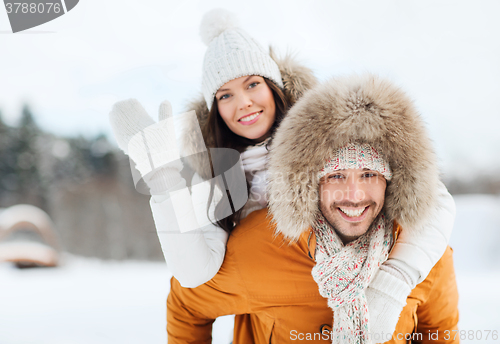 Image of happy couple having fun over winter background