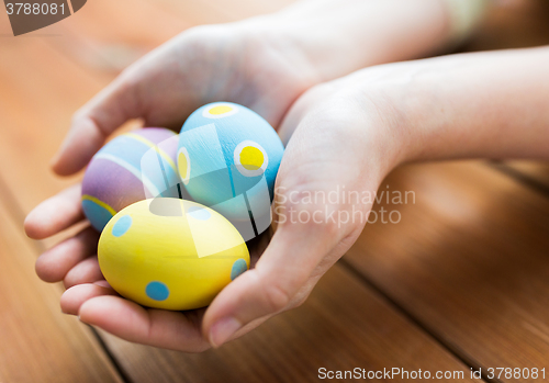 Image of close up of woman hands with colored easter eggs