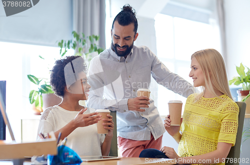 Image of happy creative team drinking coffee in office