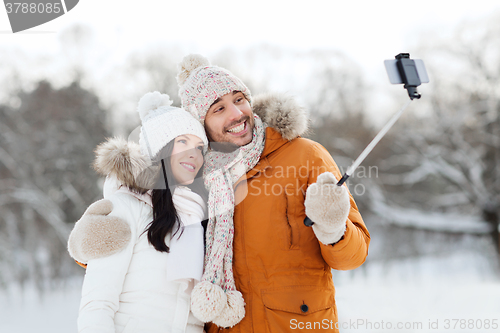 Image of happy couple taking selfie by smartphone in winter