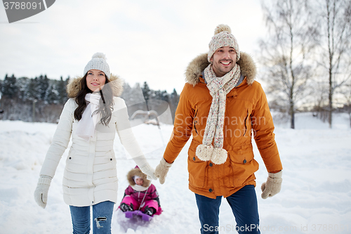 Image of happy family with sled walking in winter outdoors