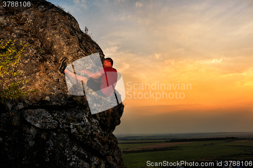 Image of Young man climbing on a wall