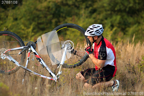 Image of man repairing his mountain bike