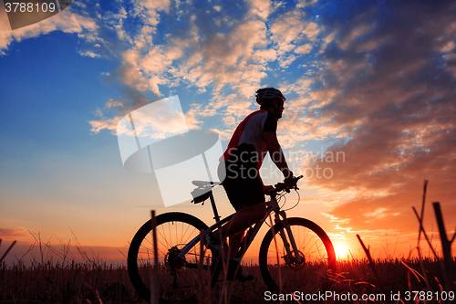 Image of mountain biker silhouette in sunrise