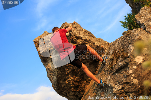 Image of Young man climbing on a wall