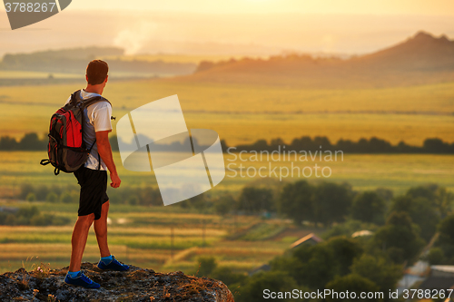 Image of Hiker with backpack standing on top of a mountain