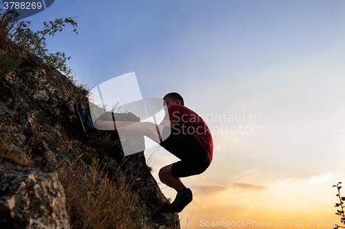 Image of Young man climbing on a wall