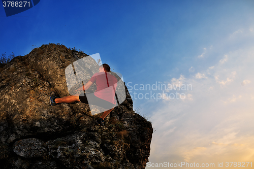 Image of Young man climbing on a wall