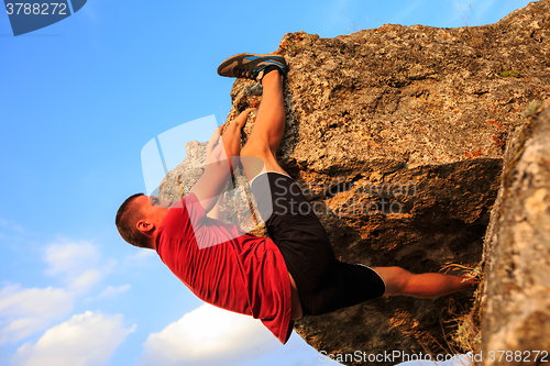 Image of Young man climbing on a wall