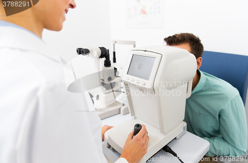 Image of optician with autorefractor and patient at clinic