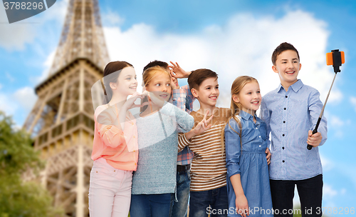 Image of kids and smartphone selfie stick over eiffel tower