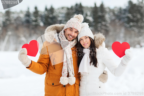 Image of happy couple with red hearts over winter landscape