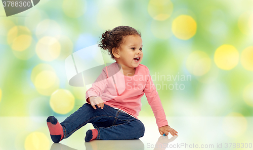 Image of smiling little baby girl sitting on floor