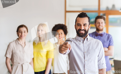 Image of happy man pointing finger at you over office team