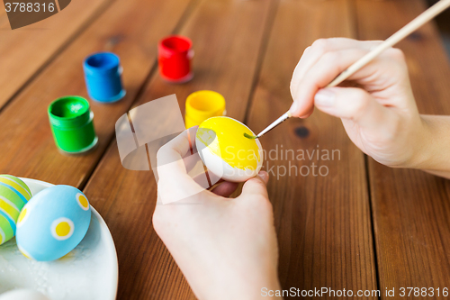 Image of close up of woman hands coloring easter eggs