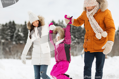 Image of happy family in winter clothes walking outdoors