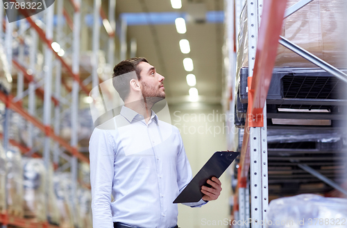 Image of happy businessman with clipboard at warehouse