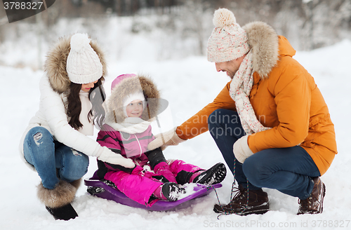 Image of happy family with sled walking in winter forest