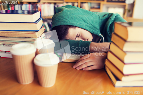 Image of tired student or man with books in library