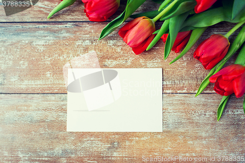 Image of close up of red tulips and blank paper or letter