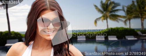 Image of smiling young woman with sunglasses on beach