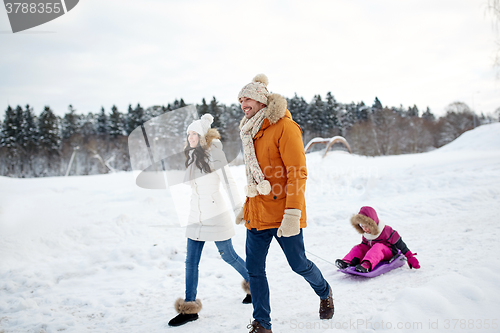 Image of happy family with sled walking in winter outdoors