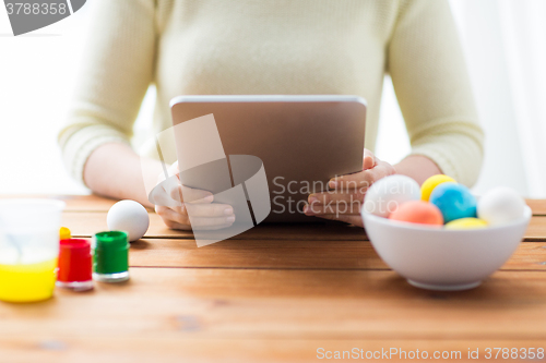 Image of close up of woman with tablet pc and easter eggs