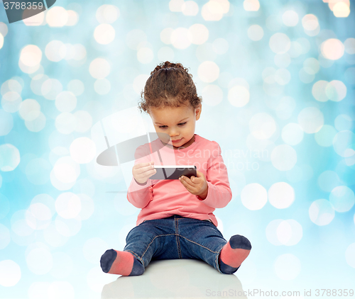 Image of smiling little baby girl playing with smartphone