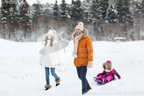 Image of happy family with sled walking in winter forest