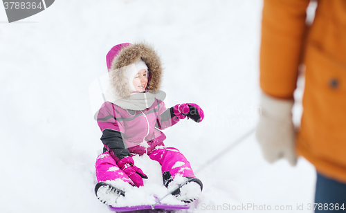 Image of happy little kid on sled outdoors in winter