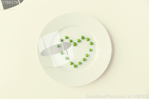 Image of close up of plate with peas  in heart shape 