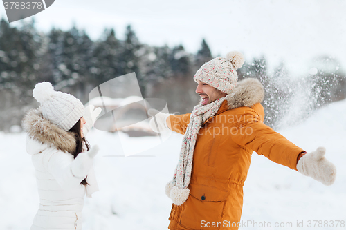 Image of happy couple playing with snow in winter