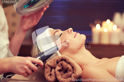 Image of close up of young woman having face massage in spa