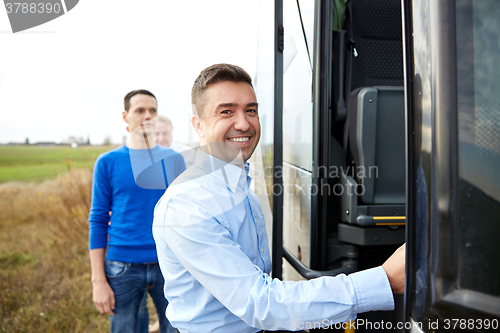 Image of group of happy male passengers boarding travel bus