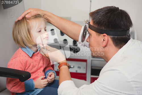 Image of Doctor ENT checking ear with otoscope to girl patient 