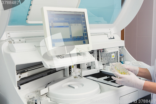 Image of Lab tech loading samples into a chemistry analyzer