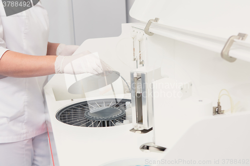 Image of Lab tech loading samples into a chemistry analyzer