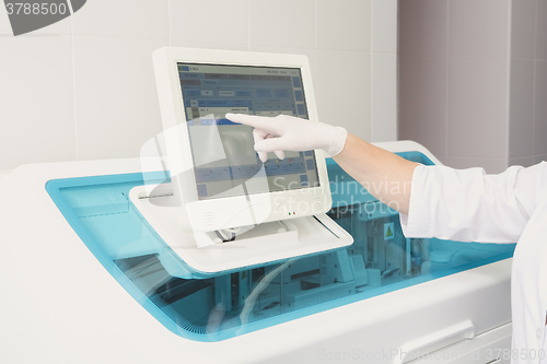 Image of Lab tech loading samples into a chemistry analyzer