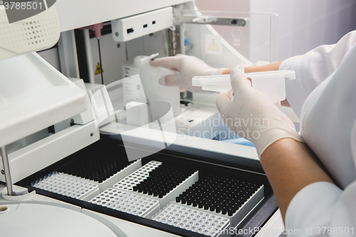 Image of Lab tech loading samples into a chemistry analyzer