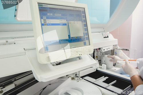 Image of Lab tech loading samples into a chemistry analyzer