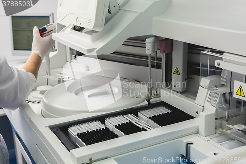 Image of Lab tech loading samples into a chemistry analyzer