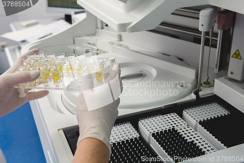 Image of Lab tech loading samples into a chemistry analyzer