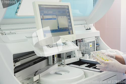 Image of Lab tech loading samples into a chemistry analyzer