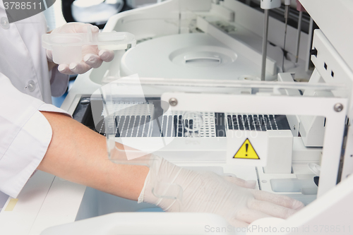 Image of Lab tech loading samples into a chemistry analyzer