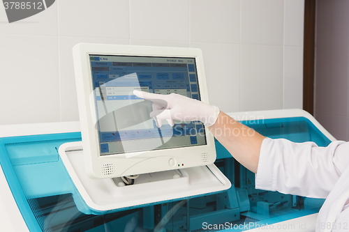 Image of Lab tech loading samples into a chemistry analyzer