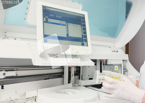 Image of Lab tech loading samples into a chemistry analyzer